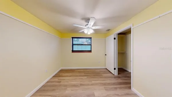 a view of a big room with wooden floor and a ceiling fan