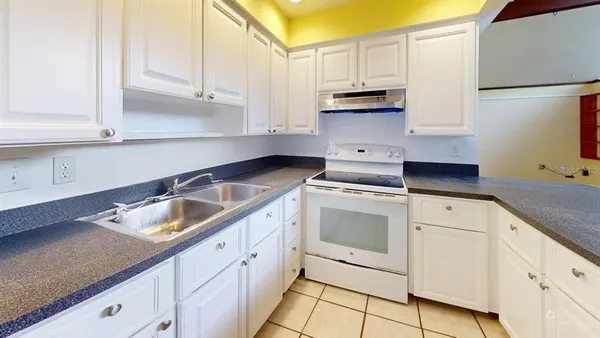 a kitchen with granite countertop white cabinets and white appliances