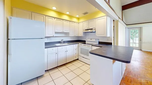 a kitchen with white cabinets and white appliances