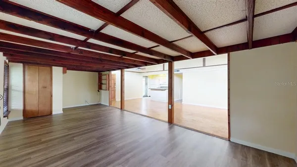 a view of an empty room with wooden floor