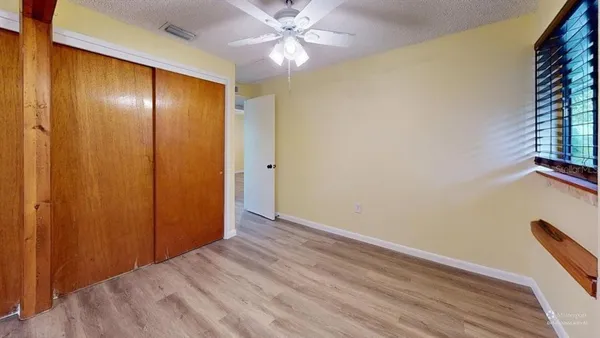 a view of an empty room with closet and a window