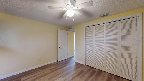 a view of an empty room with wooden floor
