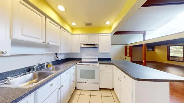 a kitchen with granite countertop a sink stainless steel appliances and cabinets