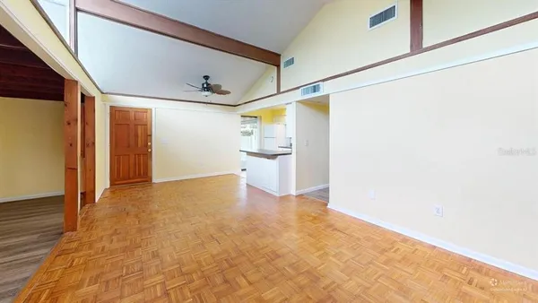 a view of a big room with wooden floor and entryway