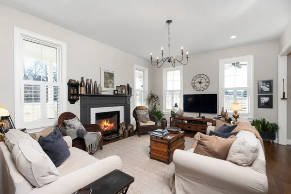 a living room with furniture a fireplace and a chandelier