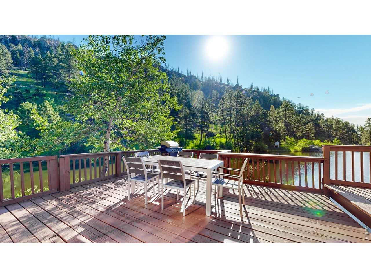 1268 Spring Valley Road Bellvue, CO 80512 - Photo 2 of 33 a balcony with wooden floor table and chairs