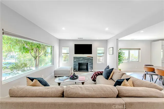 a living room with furniture fireplace and a large window