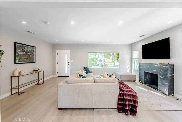 a living room with furniture a fireplace and a flat screen tv