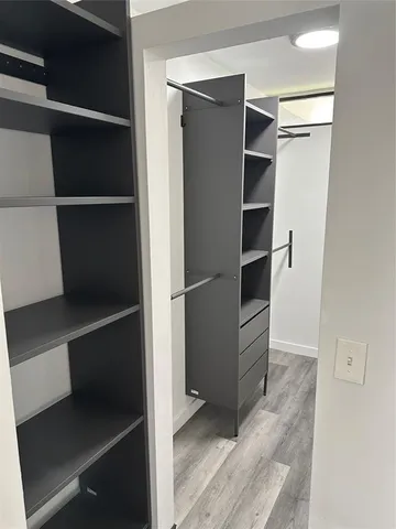 a view of walk in closet with empty racks