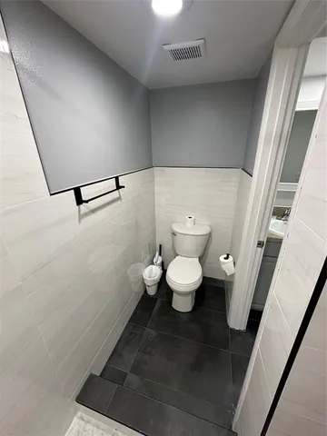 a bathroom with a double vanity sink a toilet and a mirror
