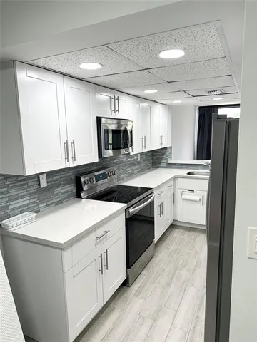 a kitchen with a sink a stove a microwave and cabinets