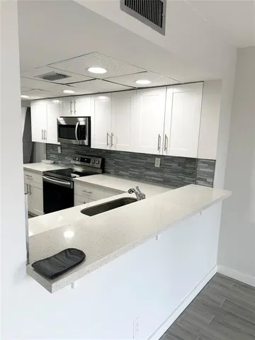 a kitchen with stainless steel appliances a stove a sink and a microwave