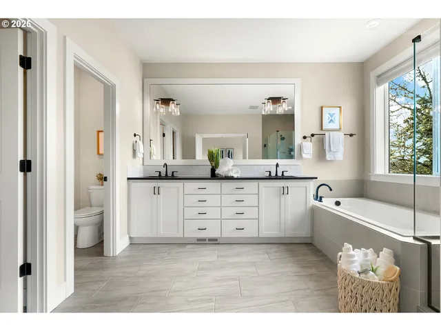 a spacious bathroom with a granite countertop sink mirror and a bathtub