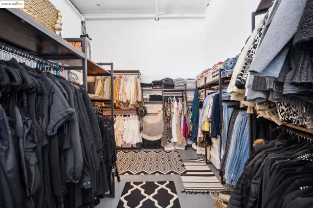a view of walk in closet with clothes and shoes