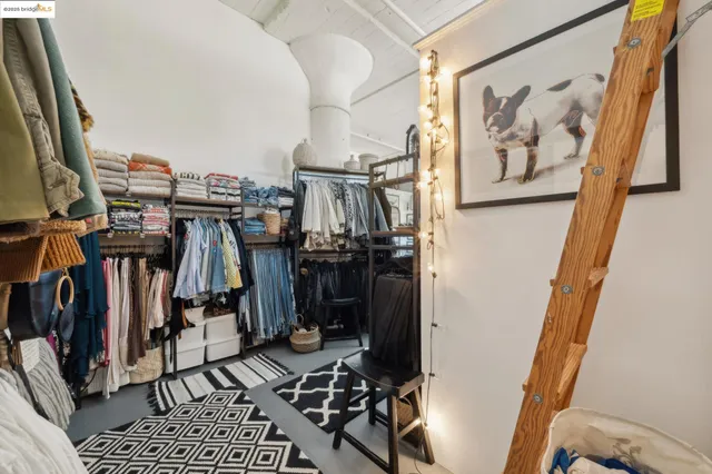 a view of walk in closet with clothes and shoes