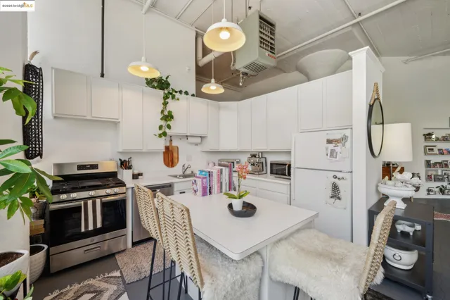 a kitchen with stainless steel appliances a table chairs and a stove top oven