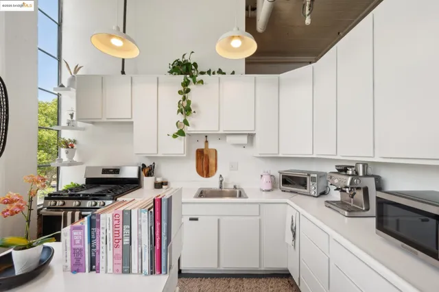 a kitchen with kitchen island granite countertop a sink a counter space appliances and cabinets