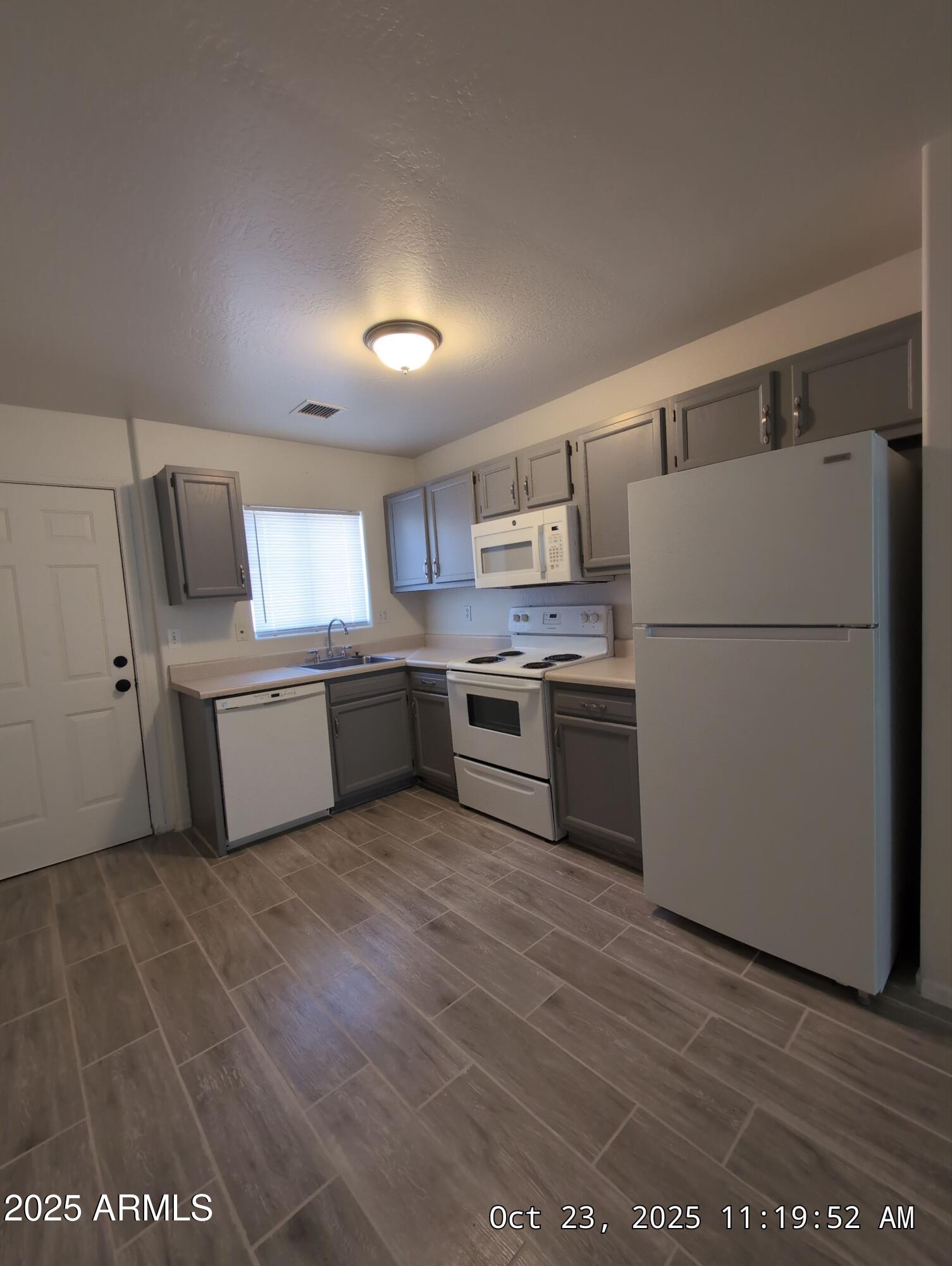 9978 West Century Drive, Unit B Arizona City, AZ 85123 - Photo 3 of 11 a kitchen with a refrigerator a sink and a microwave