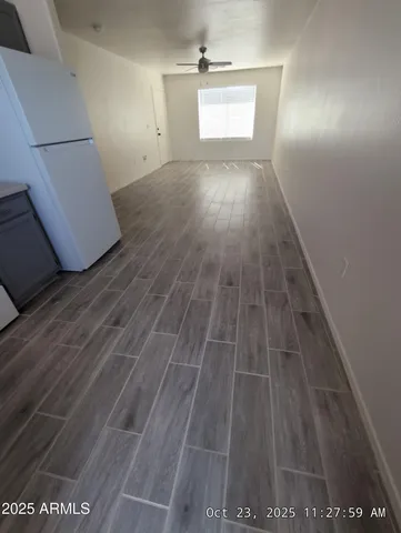 en empty room with window and wooden floor