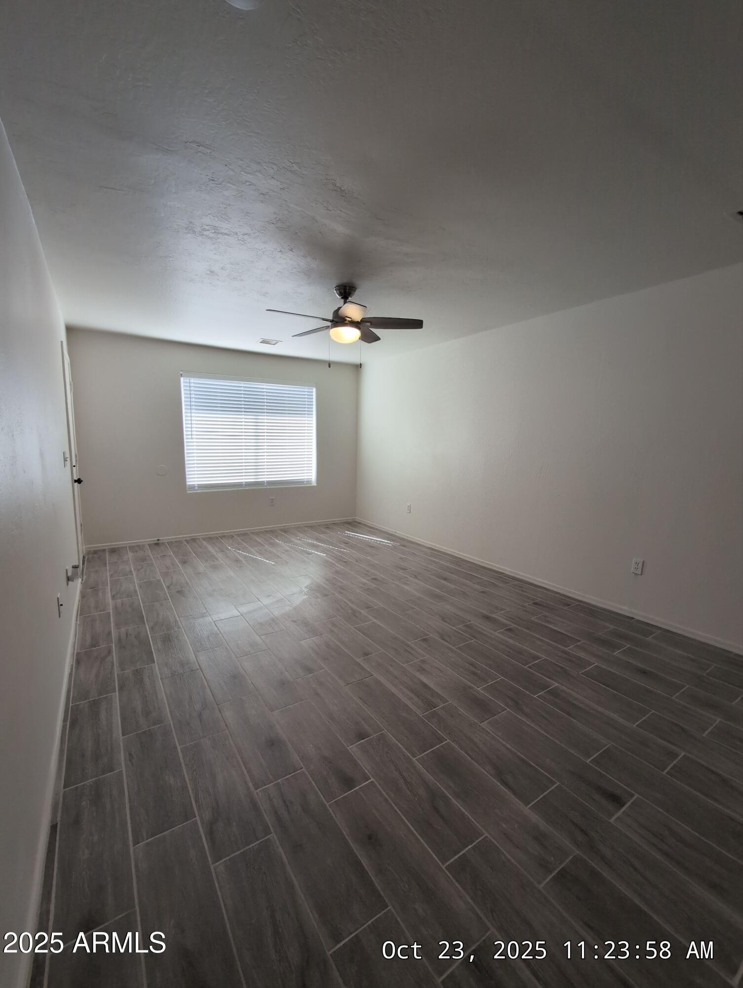 9978 West Century Drive, Unit B Arizona City, AZ 85123 - Photo 6 of 11 an empty room with wooden floor and windows