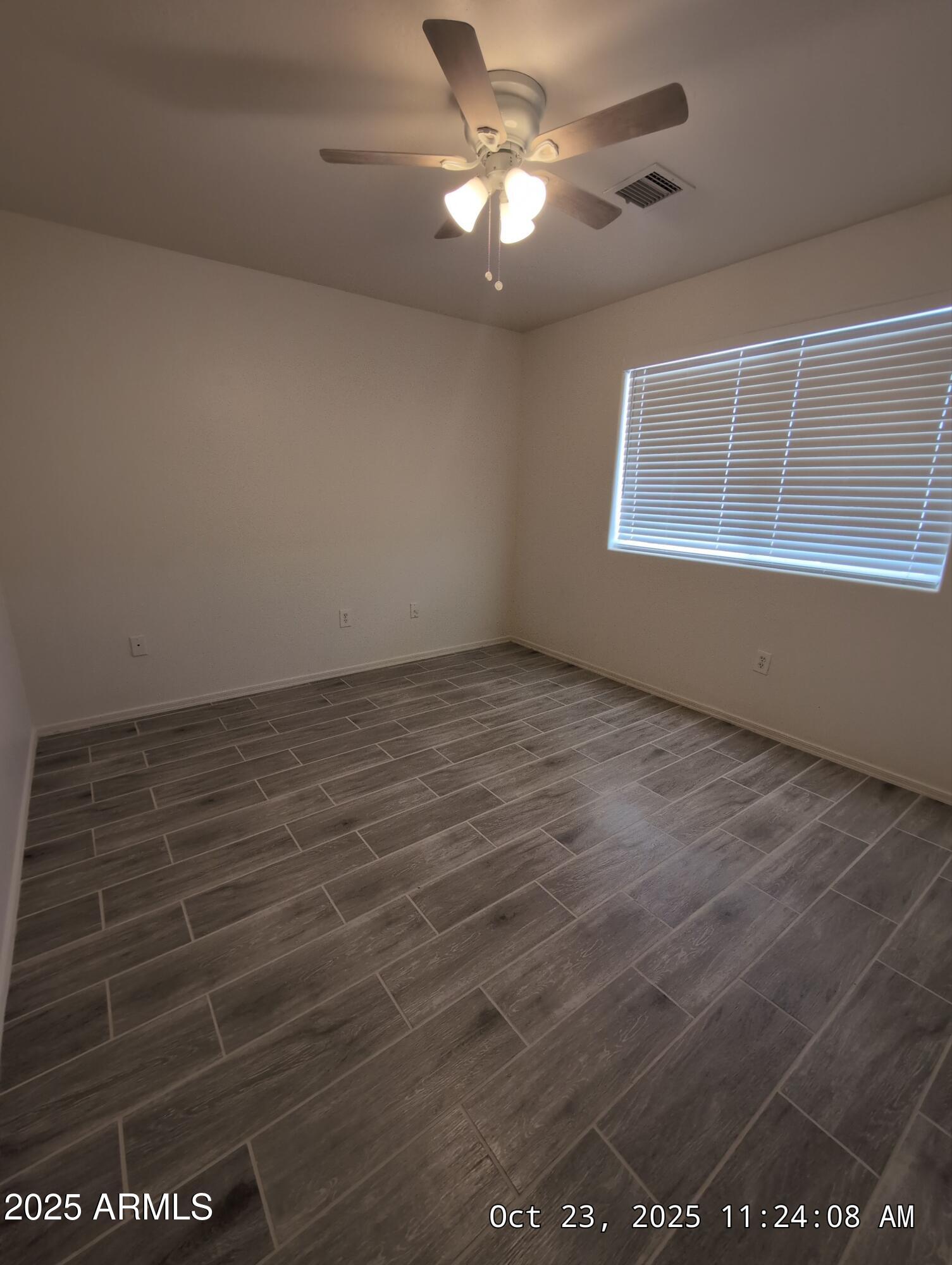 9978 West Century Drive, Unit B Arizona City, AZ 85123 - Photo 7 of 11 en empty room with windows and ceiling fan