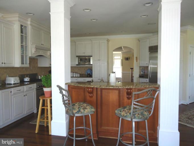 230 Bentons Pleasure Road Chester, MD 21619 - Photo 20 of 30 a kitchen with a dining table chairs and cabinets