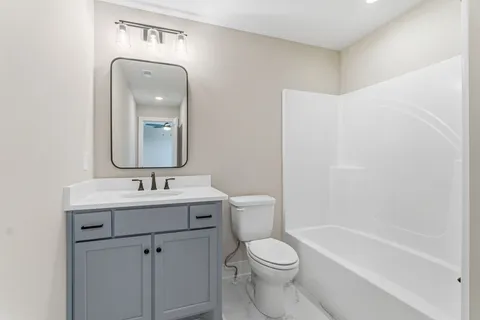 a white toilet sitting next to a bathroom sink