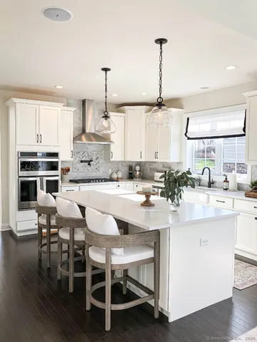 a kitchen with stainless steel appliances kitchen island granite countertop a table and chairs in it