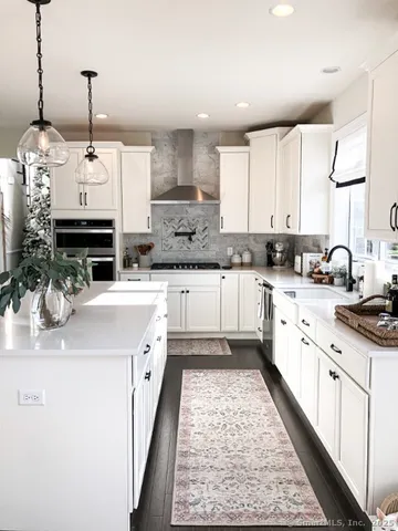 a kitchen with stainless steel appliances granite countertop a sink stove and white cabinets