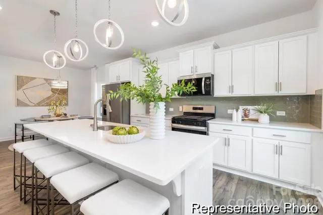 a kitchen with a sink a stove and chairs