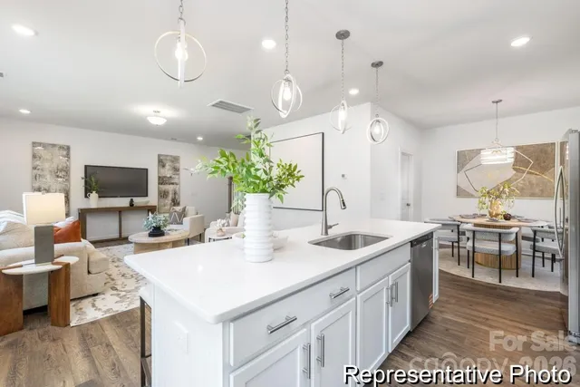 a kitchen with kitchen island granite countertop a sink and white cabinets