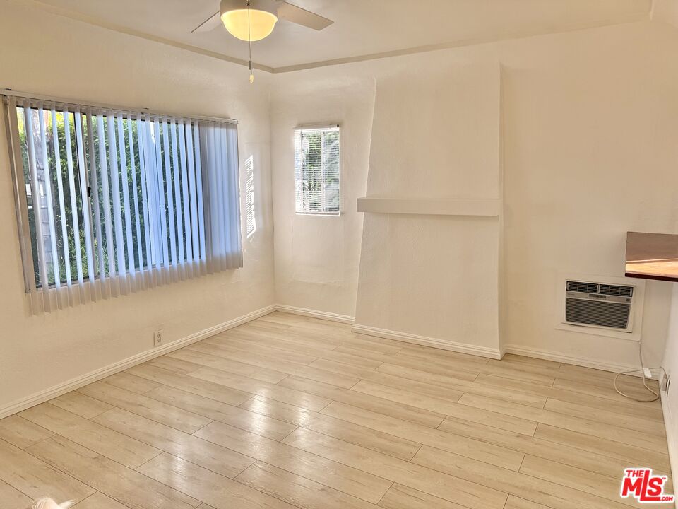 3659 6th Avenue, Unit 3661 1/2 Los Angeles, CA 90018 - Photo 5 of 23 a view of an empty room with wooden floor and a window