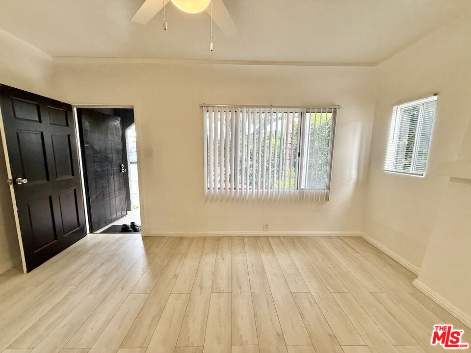 3659 6th Avenue, Unit 3661 1/2 Los Angeles, CA 90018 - Photo 6 of 23 a view of an empty room with wooden floor and a window