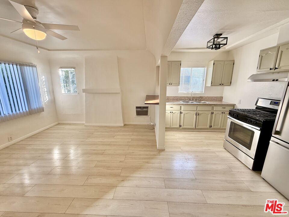 3659 6th Avenue, Unit 3661 1/2 Los Angeles, CA 90018 - Photo 7 of 23 a large white kitchen with cabinets and wooden floor