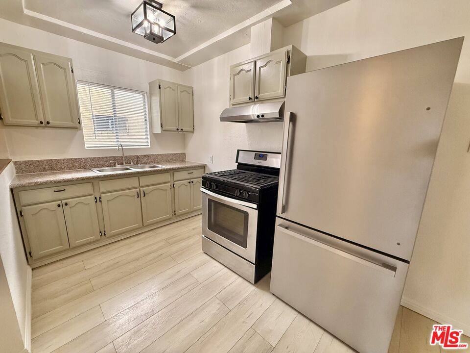 3659 6th Avenue, Unit 3661 1/2 Los Angeles, CA 90018 - Photo 9 of 23 a kitchen with stainless steel appliances a sink and a refrigerator