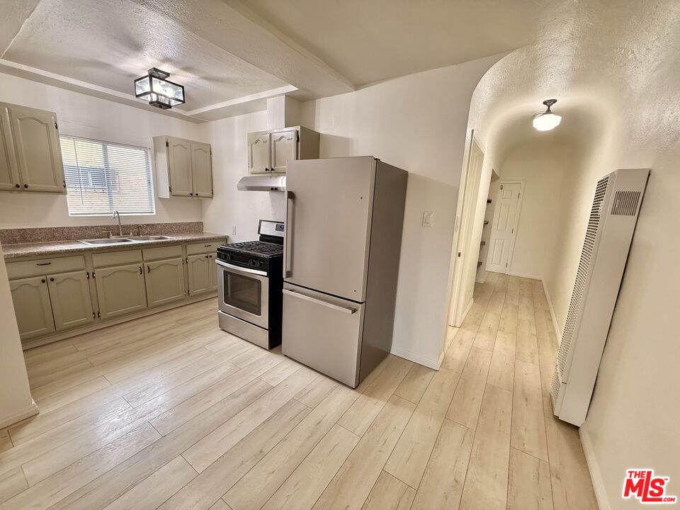 3659 6th Avenue, Unit 3661 1/2 Los Angeles, CA 90018 - Photo 10 of 23 a kitchen with granite countertop a refrigerator a sink dishwasher a stove and white countertops with wooden floor