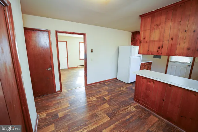 an entryway with wooden floor and cabinet
