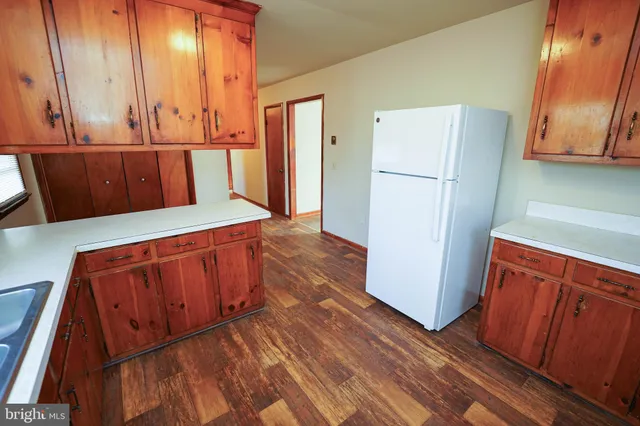 a kitchen with wooden floors and refrigerator