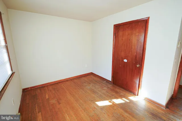 an empty room with wooden floor and closet