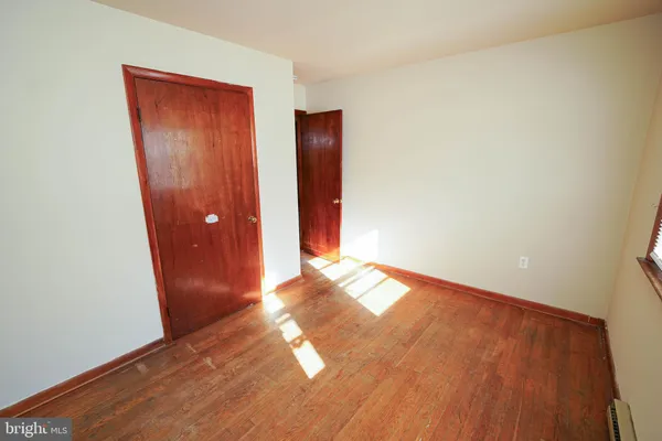 an empty room with wooden floor and closet