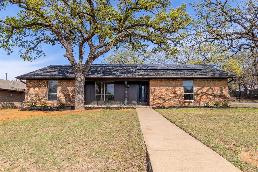 2423 Jewell Drive Arlington, TX 76016 - Photo 1 of 28 Ranch-style house featuring solar panels, brick siding, and a front lawn
