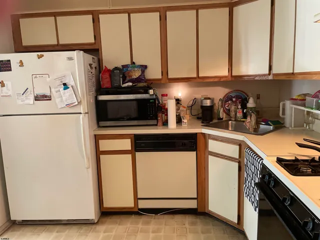 a kitchen with stainless steel appliances a refrigerator sink and cabinets