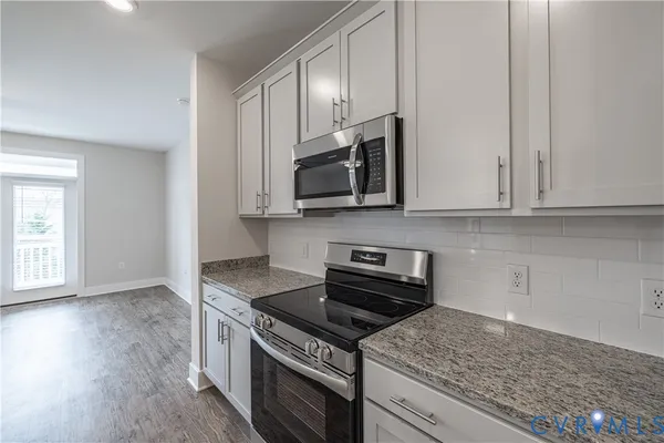 a kitchen with a sink cabinets and wooden floor