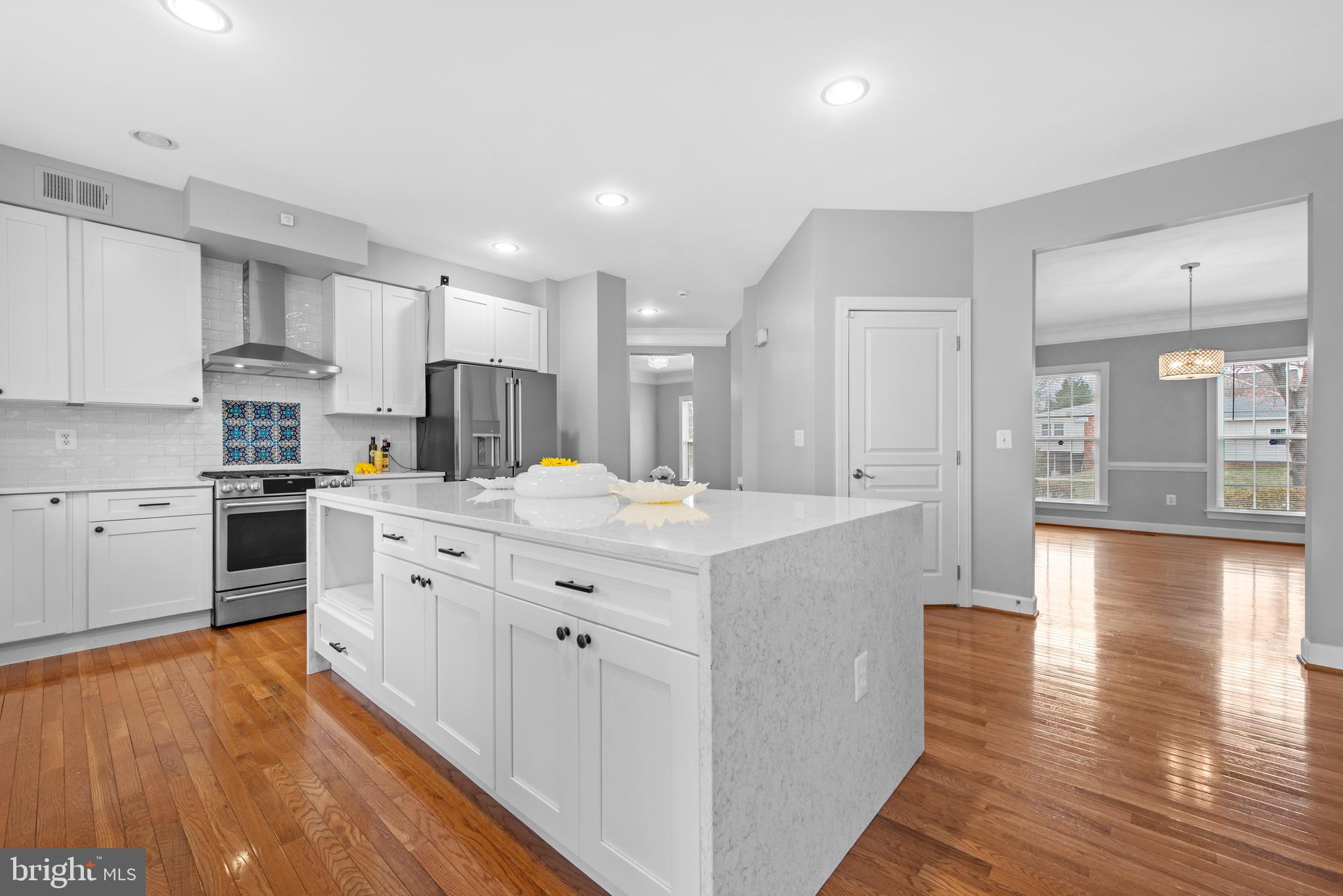 403 Madison Street Herndon, VA 20170 - Photo 9 of 63 a kitchen with stainless steel appliances kitchen island granite countertop a stove a sink a refrigerator and white cabinets with wooden floor