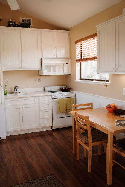 2199 Curtis Madden Road Baker, FL 32531 - Photo 46 of 63 a kitchen with a stove a sink and white cabinets with wooden floor
