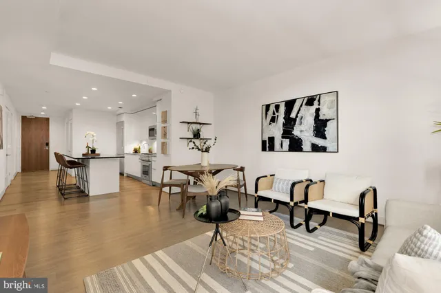 a living room with furniture and a dining table with kitchen view