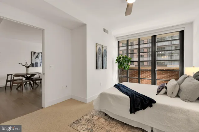 a bedroom with a bed lamps and a large window