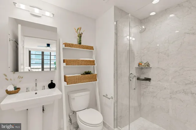 a bathroom with a sink a toilet and shower