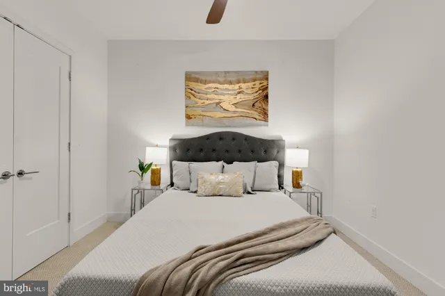 a bedroom with a bed and painting on the wall