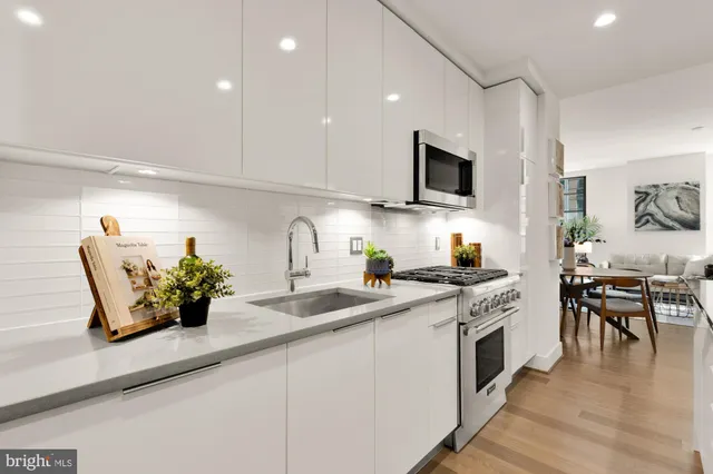 a kitchen with stainless steel appliances granite countertop a stove a sink and a microwave